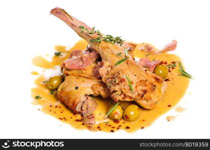 Preppared rabbit legs with ham, yellow sauce, green olives and rosemary