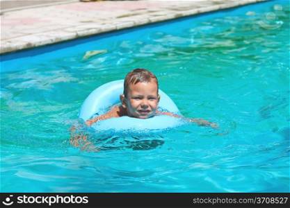 Preschool boy swims in pool on summer vacations