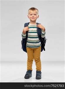 preschool education and childhood concept - portrait of smiling little boy with school backpack over grey background. portrait of smiling boy with school backpack