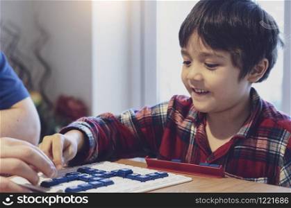 Preschool kid playing English words game,Child boy concentrated with spelling English letter with parent at home. Activity for children for play and learn, Education and Homeschooling concept