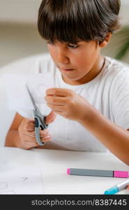 Preschooler boy cutting paper with scissors . Preschooler Boy cutting paper