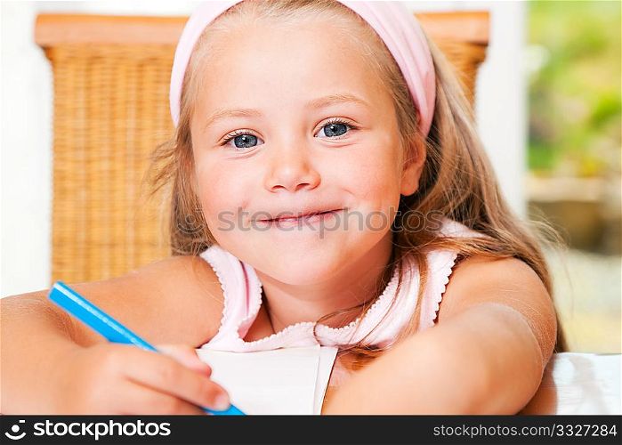 Preschooler girl drawing something using a pen