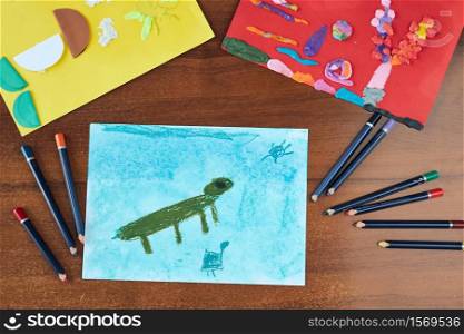 Preschooler pictures done at school. Kids drawings of animals done with crayons and paper. Concept of early education