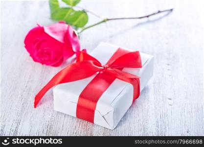 present and red rose on the white plate
