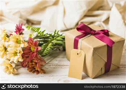 present box with brown tag flower bunch table. High resolution photo. present box with brown tag flower bunch table. High quality photo