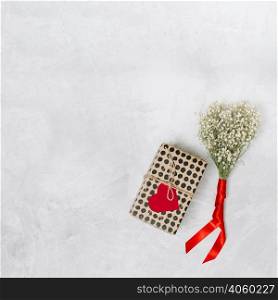 present box with ornament paper heart near plant with ribbon