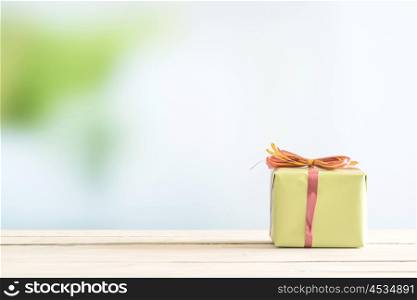 Present on a bright table in green paper wrapping