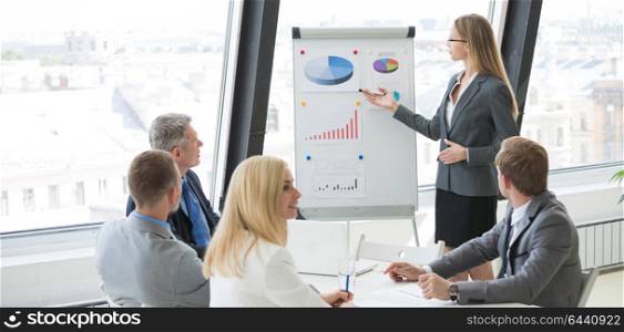 Presentation at business meeting. Business woman showing diagram during the presentation at business meeting in office