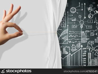 Presentation. Close up of hand opening the white curtain with business sketches behind