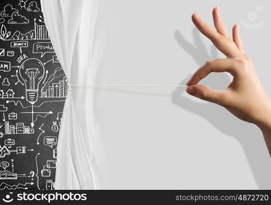 Presentation. Close up of hand opening the white curtain with business sketches behind