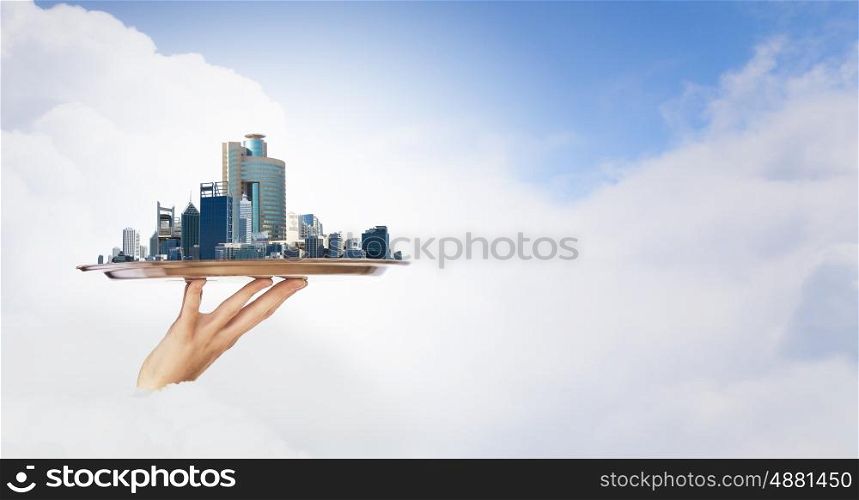 Presentation of real estate project. Hand holding metal tray with modern city model