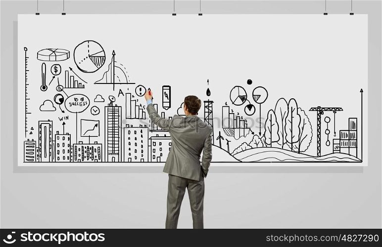 Presenting business strategy . Rear view of businessman drawing business plan on white banner