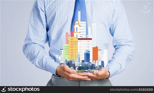 Presenting development project. Close up of businessman holding in hands construction model