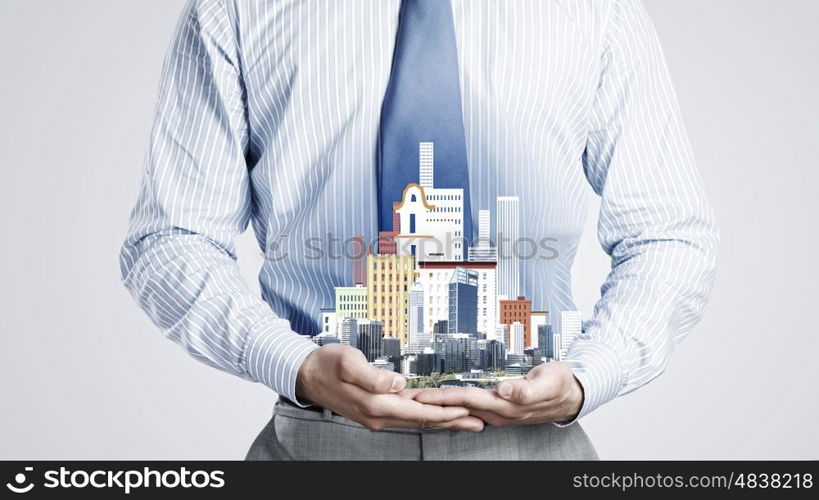 Presenting development project. Close up of businessman holding in hands construction model