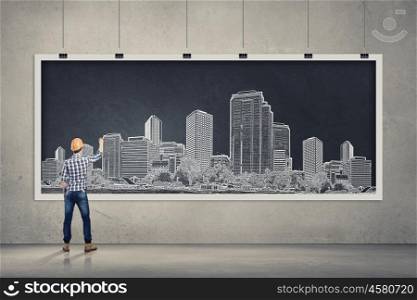 Presenting ideas. Rear view of businessman drawing business plan on banner