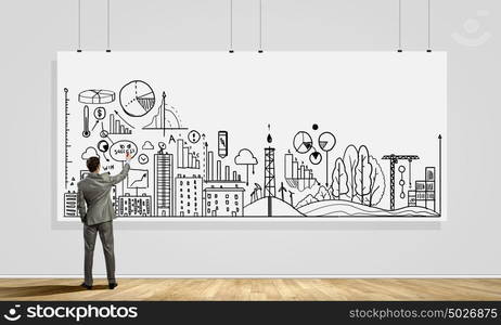 Presenting ideas. Rear view of businessman drawing business plan on white banner