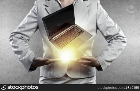 Presenting laptop. Close up of businesswoman holding laptop in hands