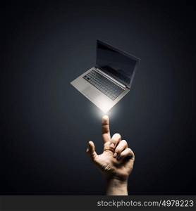 Presenting laptop. Male hand pointing with finger at laptop