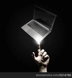 Presenting laptop. Male hand pointing with finger at laptop