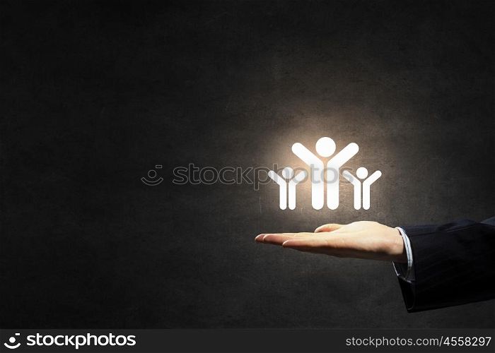 Presenting teamwork and partnership concept. Male hands holding people figures in palms as partnership concept
