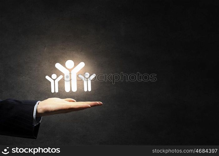 Presenting teamwork and partnership concept. Male hands holding people figures in palms as partnership concept