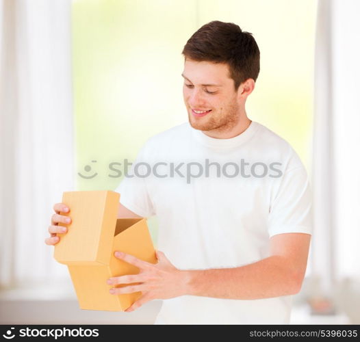 presents, gifts and celebration - man in white t-shirt with gift box