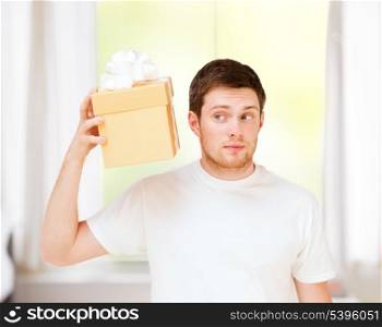 presents, gifts and celebration - man in white t-shirt with gift box