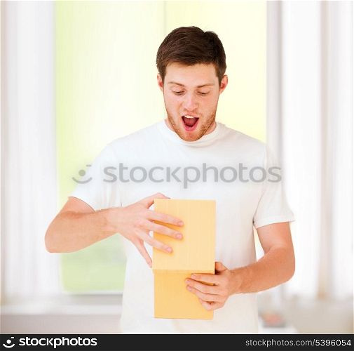presents, gifts and celebration - man in white t-shirt with gift box