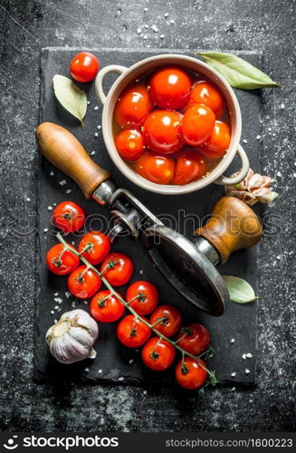 Preserved and fresh tomatoes on a stone Board. On dark rustic background. Preserved and fresh tomatoes on a stone Board.