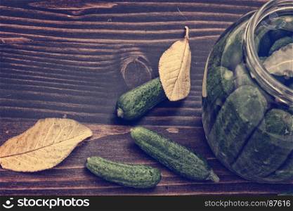 Preserved of Cucumbers: a Still Life of Autumn Yellow Leaves, Green Cucumbers and Jars with Vinegar on the Wooden Table