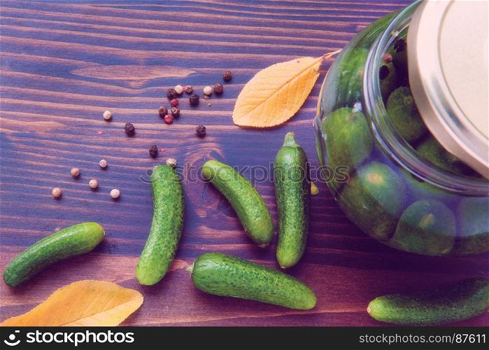 Preserved of Cucumbers: a Still Life of Dried Colorful Pepper (Black, Red, and Green), Green Cucumbers and Jars with Vinegar on the Lilac Wooden Table
