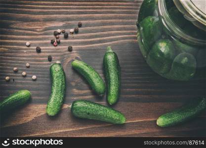 Preserved of Cucumbers: Toned Still Life of Dried Colorful Pepper (Black, Red, and Green), Green Cucumbers and Jars with Vinegar on the Wooden Table