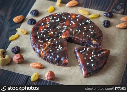 Pressed fruit and nut cake on the wooden background