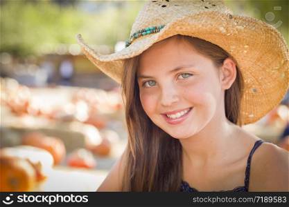 Preteen Girl Portrait Wearing Cowboy Hat at Pumpkin Patch in Rustic Setting.