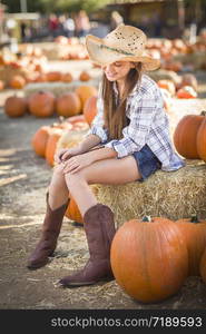 Preteen Girl Wearing Cowboy Hat Portrait at the Pumpkin Patch in a Rustic Setting.