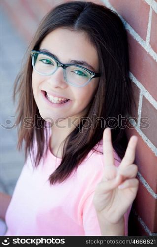 Preteenager girl next to a red brick wall with nice expression