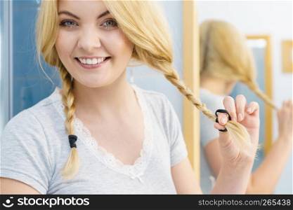 Pretty adorable woman having two cute braids on blonde hair. Haircare and hairstyling concept.. Lovely blonde woman in braids