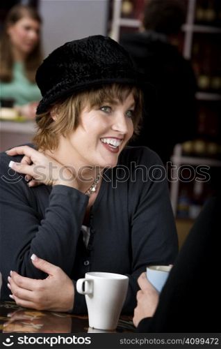 Pretty adult woman with friend in a coffee house