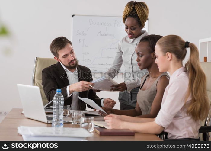 Pretty african businesswoman explaining strategy to colleagues at meeting