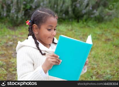 Pretty african girl with winter clothes in the park reading a book