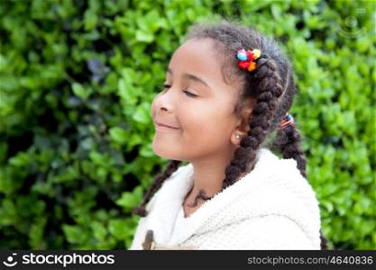 Pretty african girl with winter clothes in the park smelling