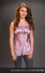 Pretty auburn haired teenager in a purple blouse and jeans