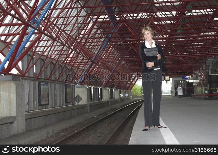 Pretty blond businesswoman waiting for the train to arrive