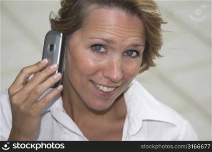 Pretty blond businesswoman with a funny look on her face while talking on the phone
