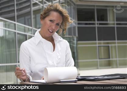 Pretty blond businesswoman working outdoors in front of her office