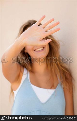 Pretty blond girl covering her face not to be in the picture