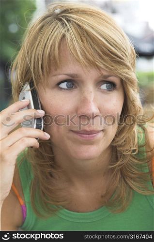 Pretty blond girl listening to the phone with a smile on her face
