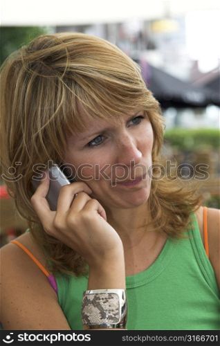 Pretty blond girl talking on the phone and looking very skeptical
