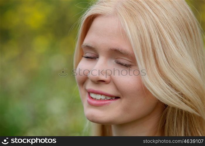 Pretty blond girl with eyes closed enjoying nature