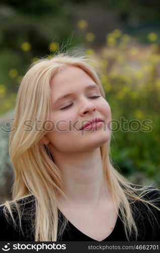 Pretty blond girl with eyes closed enjoying nature